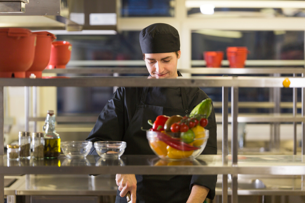 Refeitório de hotel, cozinhas abertas.